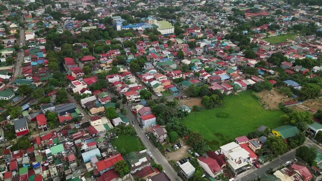 Aerial pullback revealing a dense residential neighborhood with colorful rooftops and surrounding suburban landscape in Antipolo City, Rizal, Philippines.