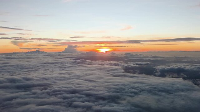 Sunset light over cloud inversion layer above Taiwan, East Asia shows stratocumulus cloud deck below and cirrus clouds above during evening golden hour atmospheric transition, shot from airplane