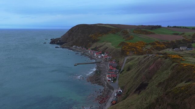 Picturesque aerial view of the historic fishing village of crovie, nestled at the base of cliffs along the aberdeenshire coast in scotland