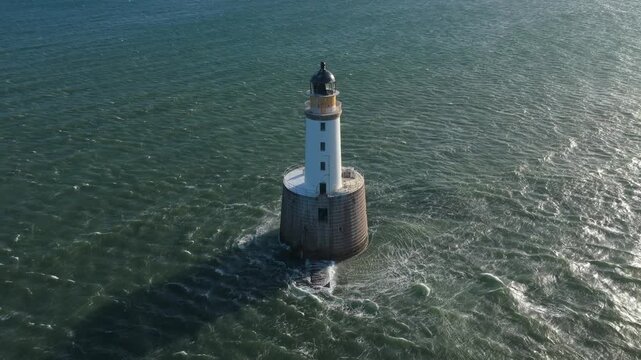 Aerial view of the historic rattray head lighthouse in aberdeenshire, scotland, standing against the restless waves of the north sea