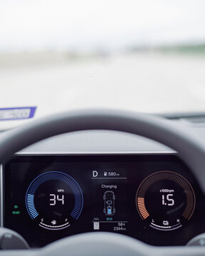 Highway Cruising Energy Recovery. Instrument monitor records speeds of 34 mph during active kinetic recovery. Luminous numerical indicators pierce through intensely bright exterior backdrops