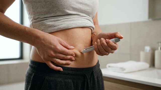 Woman injecting GLP 1 medication into stomach at home, weight loss treatment, wellness routine and healthy lifestyle concept.