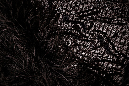 Close view of black fabric with shiny sequins and soft fur details in a fashion collection from a design studio