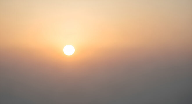A hazy, soft-focus view of the sun setting or rising through a dusty atmosphere.