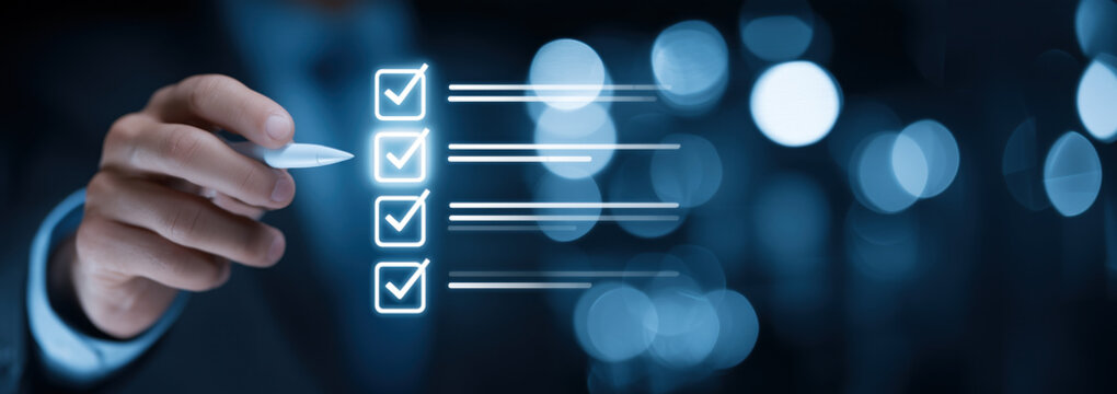 Business hand using pen to check digital checklist interface. Close up of glowing checkboxes with list items on blue background representing task management and progress