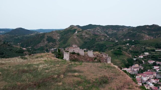 Drone on an ancient tower in Amantea, Italy. On a high hill on the seashore above the city. A cloudy summer day