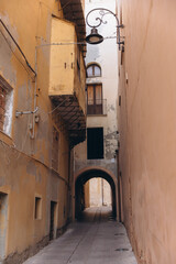 Obraz premium Cagliari old town alleyway, narrow historic street with traditional architecture and arched passage in Sardinia, Italy