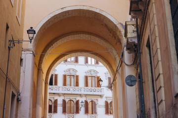 Obraz premium Cagliari city archway street view displaying historic Italian architecture, traditional windows, and old street lamps