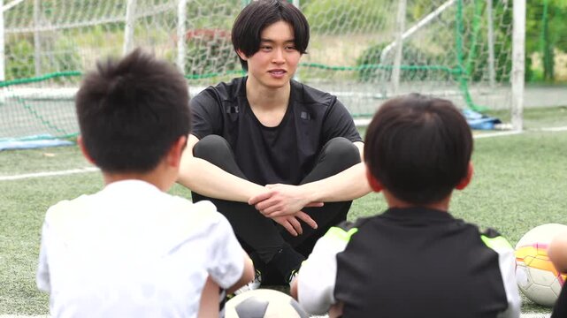 少年サッカーチームに指導する若い男性コーチ