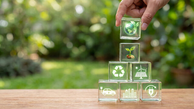 Green sustainability concept with glass blocks showing recycling solar energy electric vehicle smart city and global ecology icons for environmental responsibility and clean energy transition