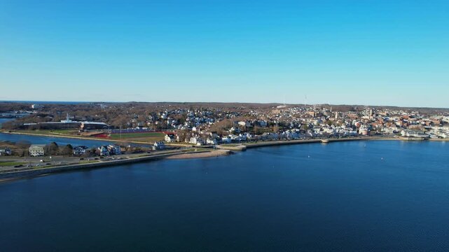 Aerial view of Gloucester town, showing residential homes, street traffic, ocean and Blynman Canal, Massachusetts, USA
