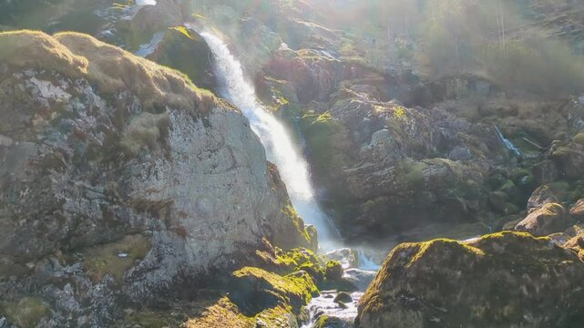 Dramatic Sunlit Cascading Waterfall with Lens Flare and Sparkling Mist at Briksdal Glacier Norway