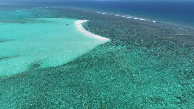 Aerial view of a white sandbank surrounded by turquoise coral reefs and clear tropical waters in Thoddoo, Alif Alif Atoll, Maldives.