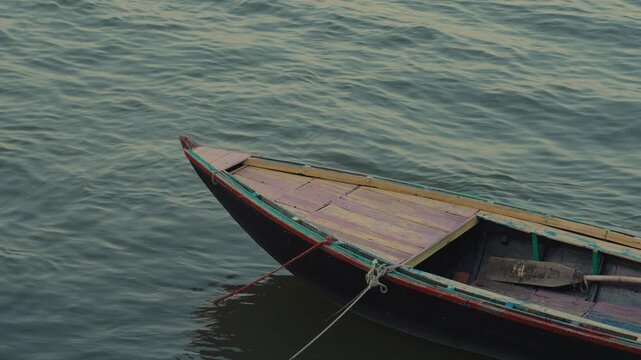 close up shot of a boat on the ganga river in varanasi, capturing calm water and subtle movements.