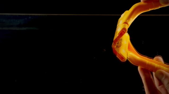 Hand Using Yellow Squeegee to Clean Soapy Glass Surface