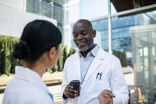 Two doctors discussing during coffee break outside hospital
