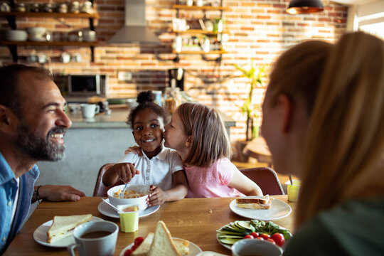 Family breakfast with affectionate children in a cozy home kitchen