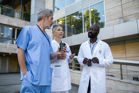 Medical team talking over coffee outside hospital