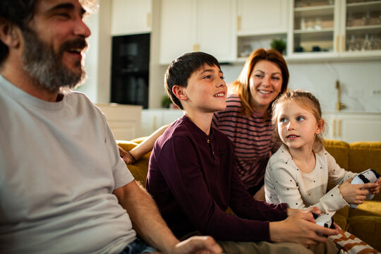 Parents and children playing video games at home
