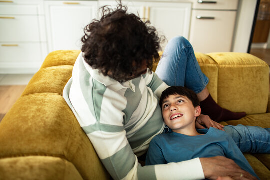 Father and son relaxing on sofa at home