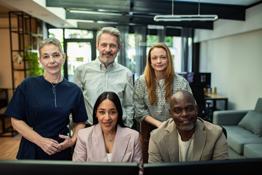 Portrait of diverse colleagues at computer monitors in modern office