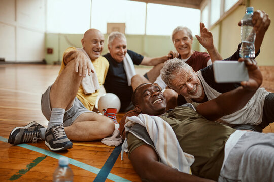 Senior men taking a post-game selfie in gymnasium