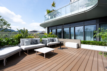 Obraz premium Modern high-rise terrace with wooden flooring and comfortable outdoor lounge area