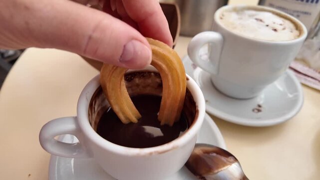 Churros, traditional, fatty Spanish pastry in the form of a long rod with a star-shaped cross-section, served with hot chocolate.