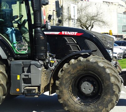 Black Fendt 724 Vario tractor driving through city street