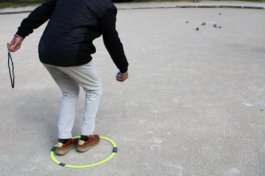 Joueur de p&eacute;tanque concentr&eacute; en train de tirer ou pointer sur un terrain ext&eacute;rieur