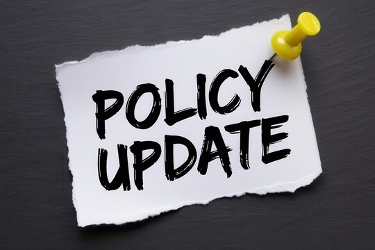 Policy update text on a ripped piece of paper with a yellow push pin