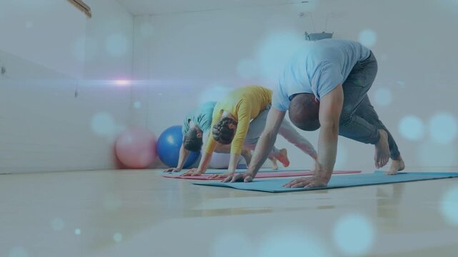 Three adults holding pose on mats, starting single-leg lifting for yoga, bokeh accenting leg lifts