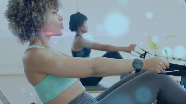 Lead rower pulling handle, bokeh floating over rowers, coach gesturing cueing synchronized fitness