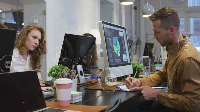 Team at desk, man moving mouse causing globe overlay linking pie chart for business analysis