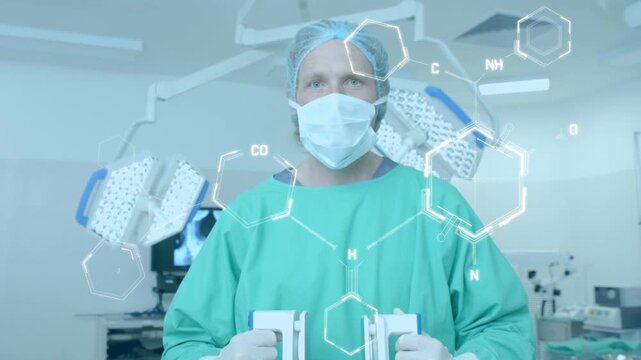 Male surgical clinician holding devices in OR, demonstrating with AR molecules fading right to left