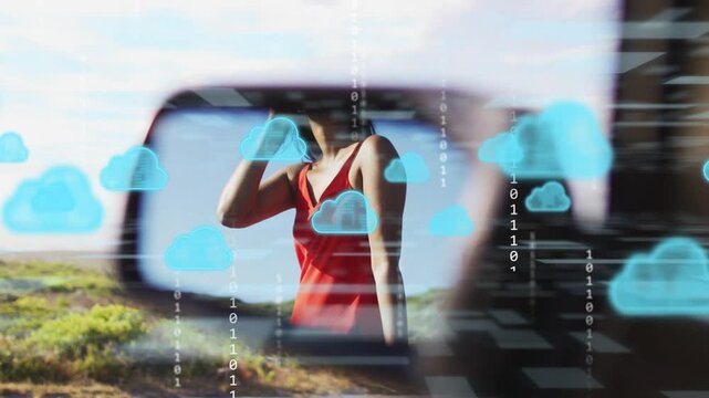 Woman taking call by car cloud icons bits appearing then receding in mirror adjusting shades tech