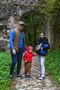 Family standing at a historic stone gate in Samobor, Croatia, surrounded by lush greenery and medieval ruins. This iconic and scenic landmark near Samobor Castle is a popular tourist destination.