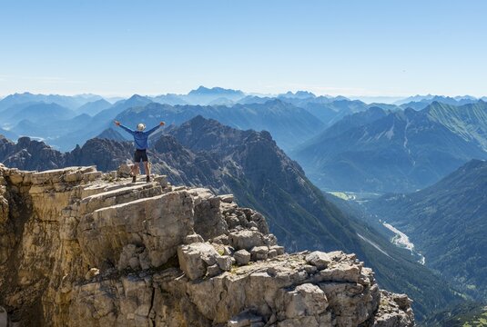 Hiker stretching arms in the air, mountains and Alps, summit of Hochvogel, Allg&auml;u, Allg&auml;u High Alps, Bavaria, Germany