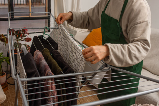 Anonymous man hanging kitchen cloth on drying rack close up