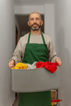 Smiling hispanic man carrying wet laundry basket through home hallway