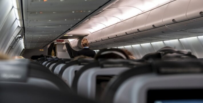 Interior of an aircraft, stewardess, rows of seats in an aircraft