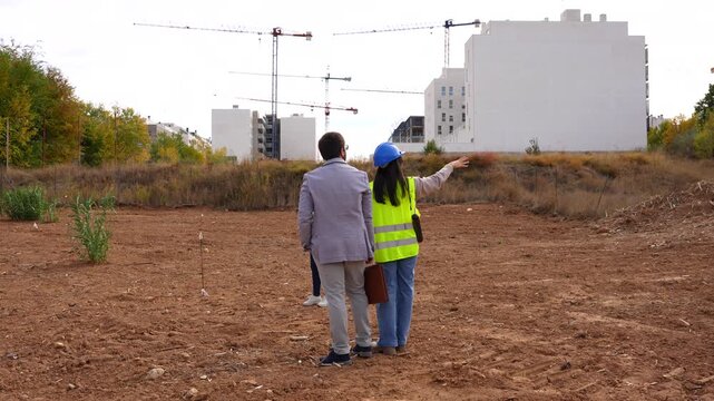 Team of architects and investor visiting a construction site for a new residential building