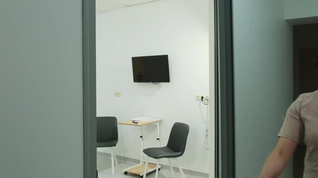 Nurse with mask shows ward interior with adjustable bed in hospital slow motion. Female medic opens door of recovery room in healthcare facility