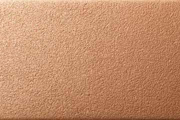 Fototapeta premium Warm brown cork wall texture with fine grain detail and subtle lighting creating natural organic pattern and warm atmosphere