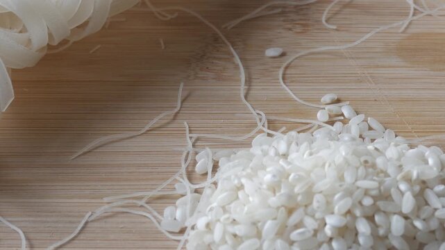 Close-up of rice noodle and rice grains on wooden surface