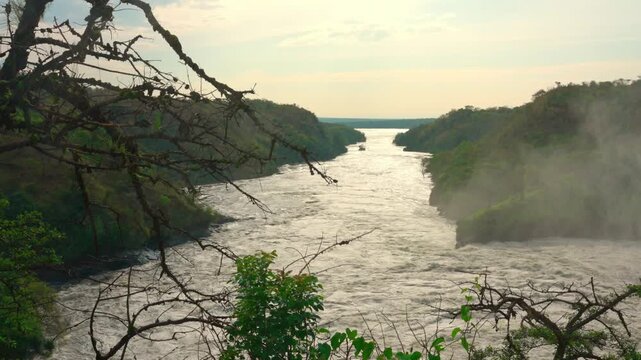 Flowing Nile River at Murchison Falls, Uganda, with water spray rising from the cascading falls.