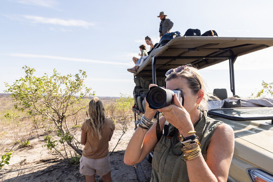 woman photographing on safari, Makgadikgadi Park, Botswana, Africa