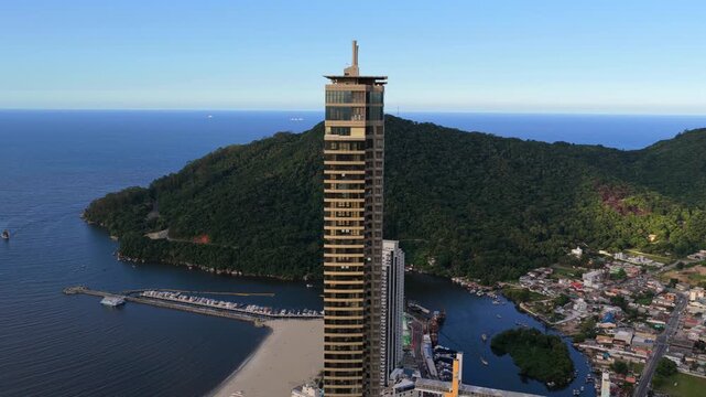 Twin skyscrapers rise above Barra Sul, offering a panoramic view of the coastline and lush hills. Ideal for architectural features or travel promotions.