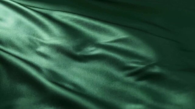 A close-up view of a smooth green fabric texture with folds