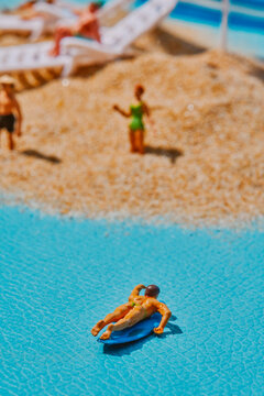 a miniature surfer floating near the shore